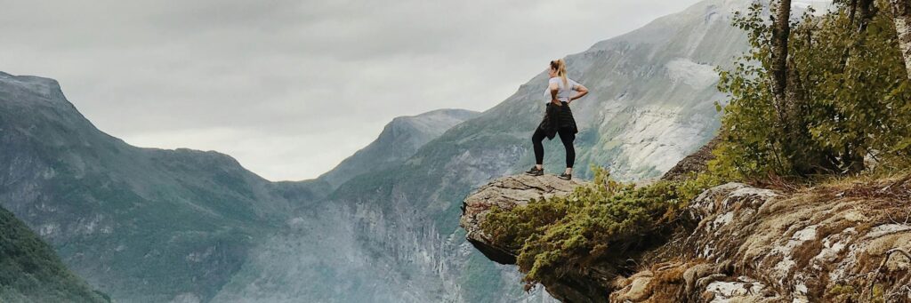 Une femme marche sur un rocher en altitude