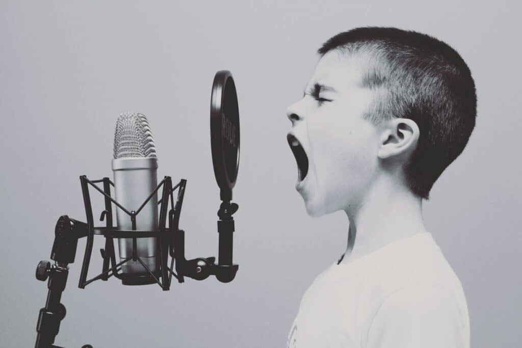 Un enfant criant face à un micro.